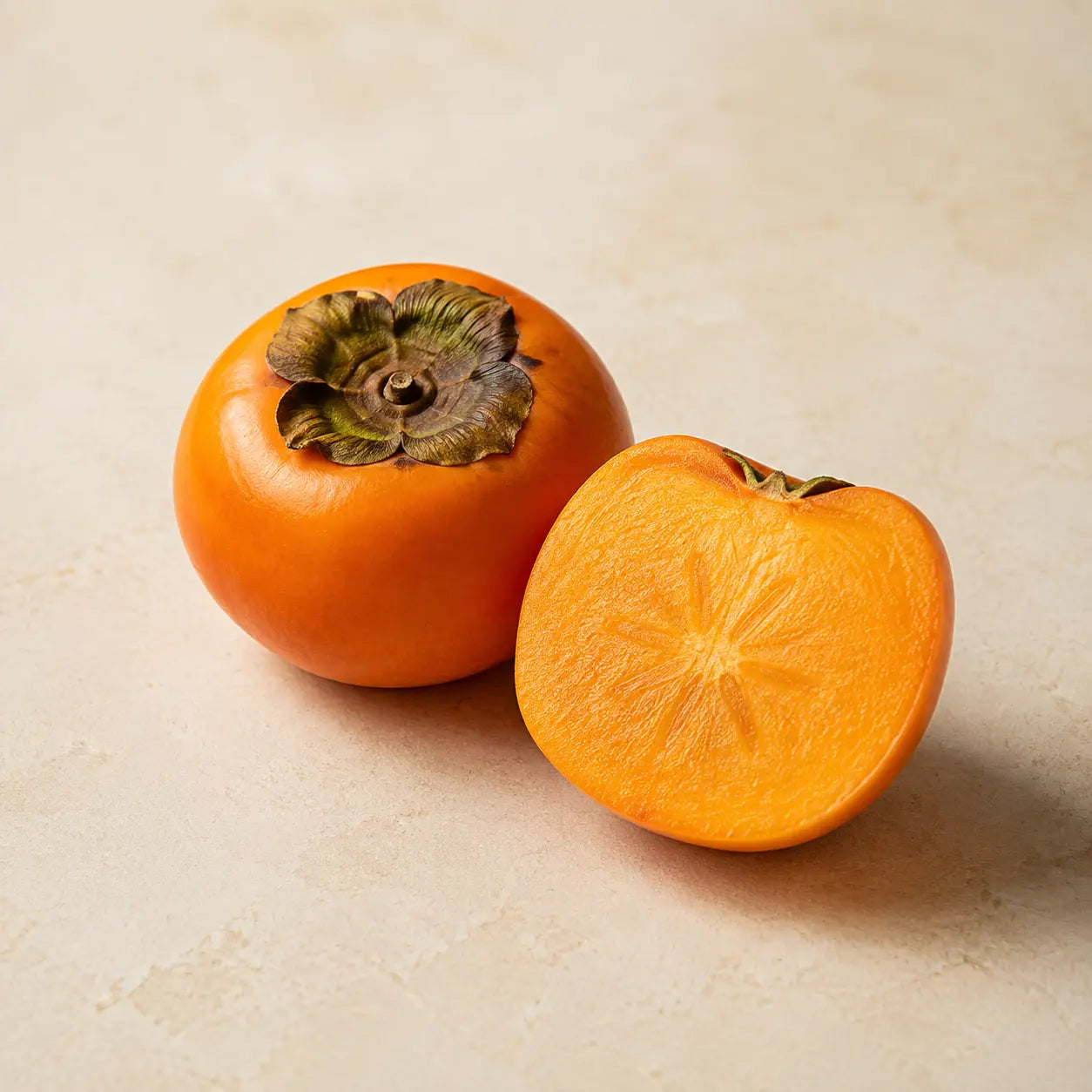 Whole and freshly cut ripe Japanese persimmon fruit